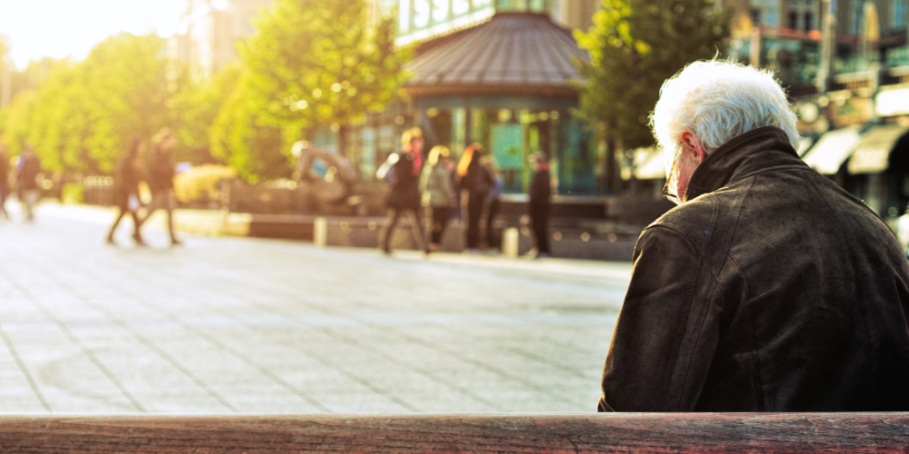 Elderly man sitting alone on bench