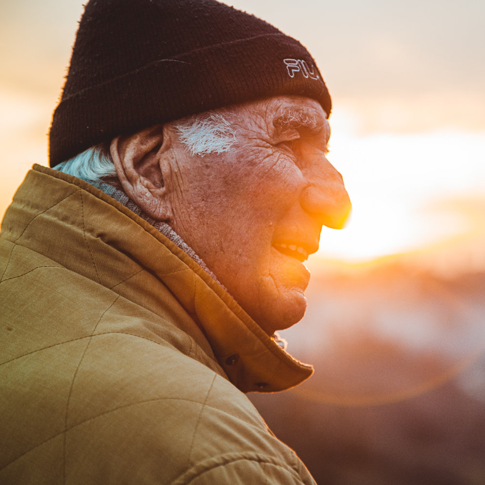 Elderly man in front of a sunset